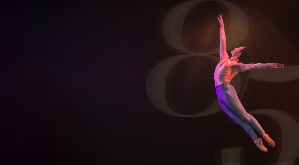 an athletic shot of a male dancer in blue pants in warm pink light and 85 photo-shopped behind him