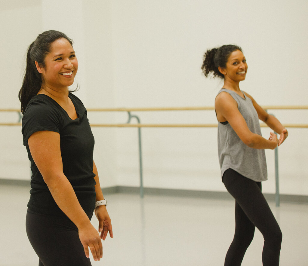 Two women taking a dance class with big smiles on their face