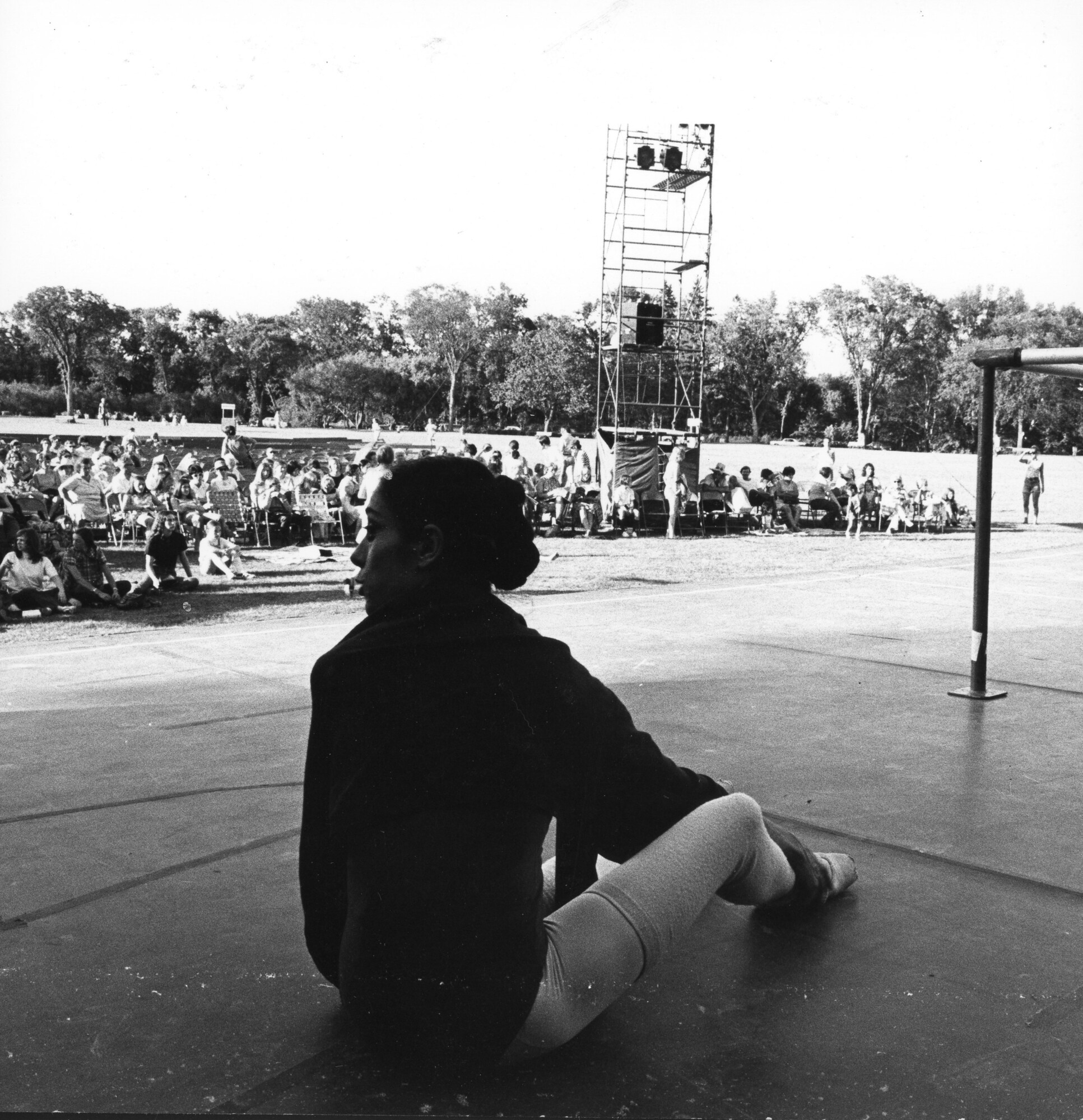 Black and white photo of Ana Maria de Gorriz at Dancing in the Park in 1972 sitting in the grass with a crowd of people in lawn chairs